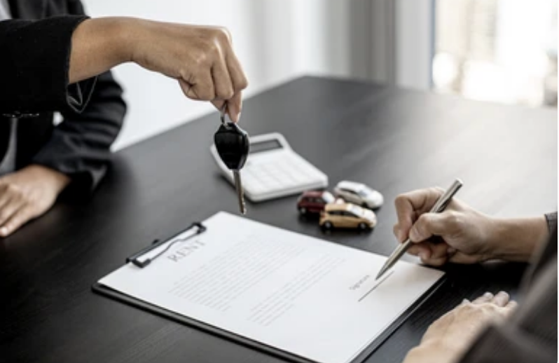 Someone signing a lease agreement for a car